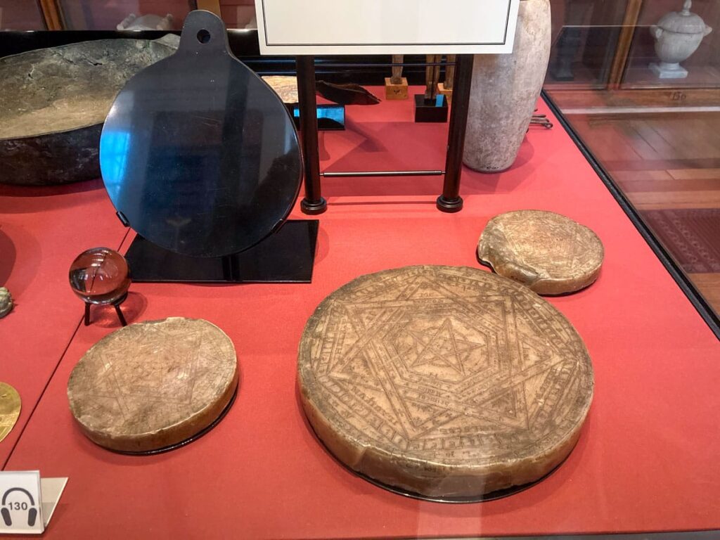 Espejo de obsidiana (arriba a la izquierda) y varios sellos mágicos pertenecientes a John Dee. Ah, y una bola de cristal.